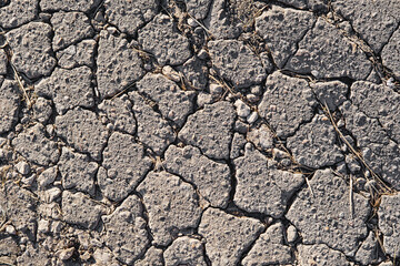 Close-up of cracked asphalt texture. Cracks on the old road surface. Abstract background.
