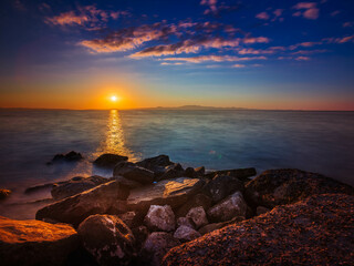 Widok skał oblewanych przez morze o wschodzie słońca przy kolorowym niebie © Michal45