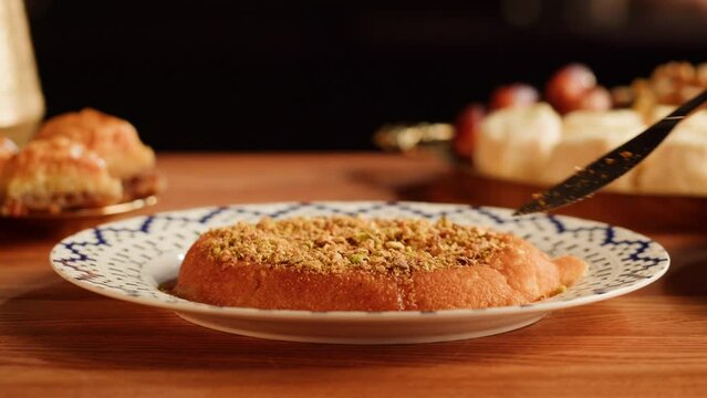 Arabic traditional sweets, kunafa dish close-up. Middle eastern national food desserts. Muslim family dinner, Ramadan, iftar. Arabian cuisine delivery.