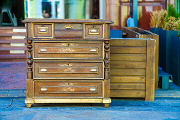 An old chest of drawers stands on the sidewalk