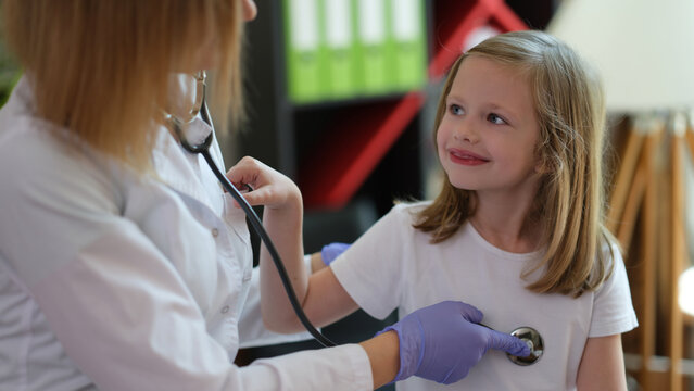 Children doctor examines little girl at home