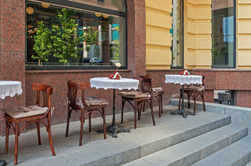 Wooden chairs and round tables on summer terrace