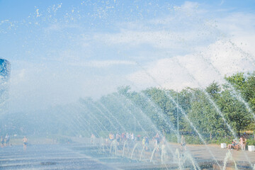 Clean water running from many taps with sparkling drops.Splash of water in the fountain.Water arches against the sky
