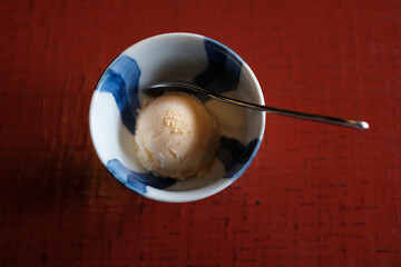 gourmet Japanese ice cream in a decorative bowl with spoon on a red table