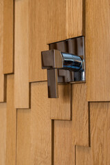 Chrome-plated water mixer faucet built into the wall in the interior