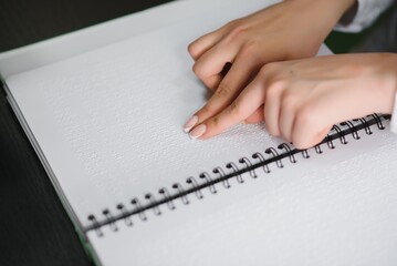 Blind woman read book written in Braille