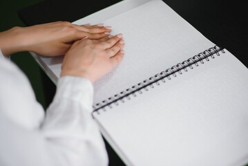 Blind woman read book written in Braille. Close up finger touch to braille Code