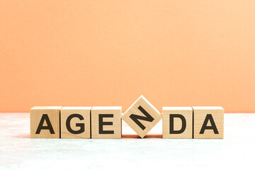 AGENDA text on a wooden blocks, orange background