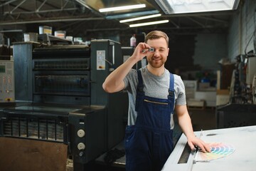 Portrait of production line worker controlling manufacturing process of modern packaging industrial...