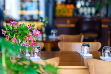 An inverted glass stands on a napkin on a table in a cafe.