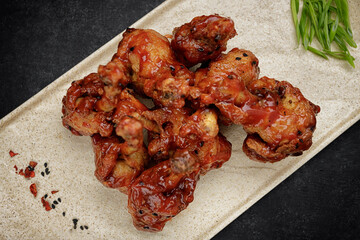 Grilled chicken legs in sauce, on a dark background