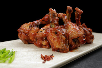 Grilled chicken legs in sauce, on a dark background
