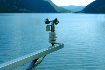 modern device anemometer over alpine lake controls parameters, meteorological equipment measures...