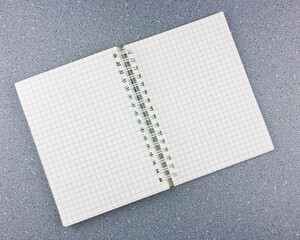 Notepad in a cage on the background for text.Blank paper open business notebook empty pages, with cells. Notebook open with a sheet in a cage with a place for text.
