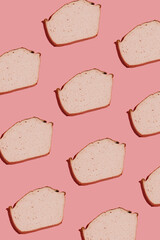 hard light pattern of a slice of traditional oven baked bavarian meal leberkäse - meat dish made of corned beef, pork and bacon, finely ground and baked as a bread loaf, pink background