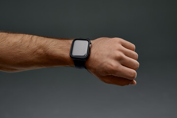 Fototapeta premium Male hand close up. Man using black smart watch, checking heart rate after workout, copy space