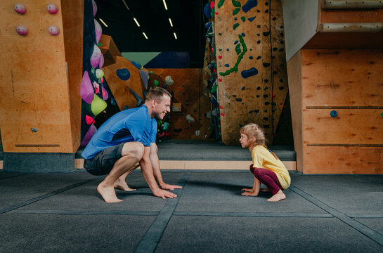 Father and daughter doing squats in a gym - Powered by Adobe