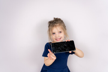 Baby girl holding broken smartphone showing cracked screen looking positive and happy standing and smiling over isolated background. Worried child accidentally destroyed smartphone