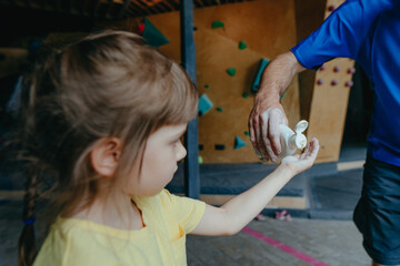 Rock climber father and daughter climbing in a modern gym