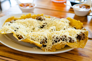 typical colombian ground beef patacon with lots of cheese and ahogado