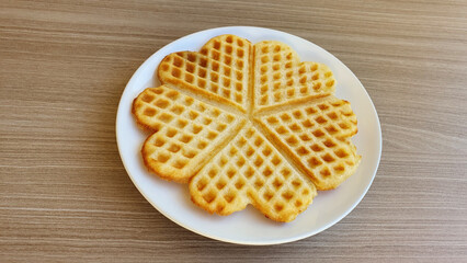 Homemade Belgian waffles in the shape of a heart on the table.