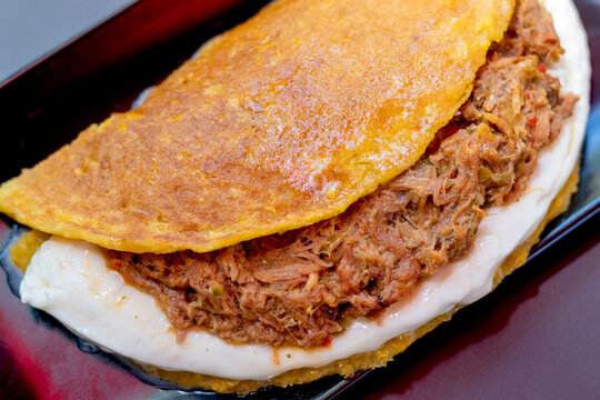 Cachapa with pulled meat, corn tortilla with cheese, meat and butter