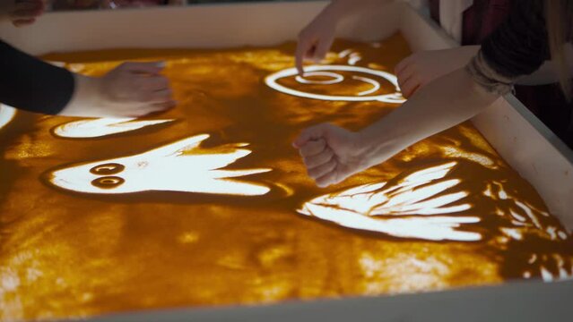 Sand animation, woman hand drawing on sand table light box. Education painting on sand. Leisure activity for creative growth for kids High quality 4k footage Handheld