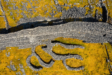 Remains of Black fort on Aran Island. Aerial drone view. County Galway, Ireland. Popular tourist landmark. Stone building on a rough rock terrain by the ocean. Cloudy sky and blue ocean water
