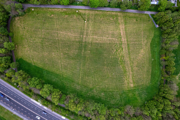 Top down view on a small park by a motor way. Green field and trees. Fresh air and nature in town area.