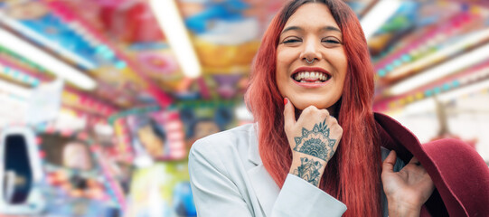 smiling hipster girl with tattoo and hat at fair or amusement park