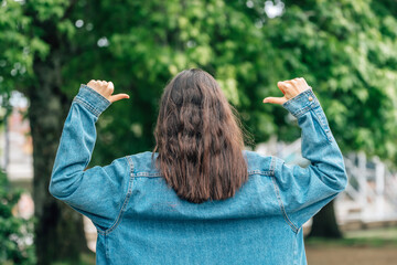 girl from behind with okay gesture pointing