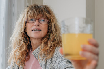 middle aged woman with glass of orange juice