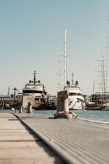 Fishing Vessel. Vertical detail photo of a maritime dock with yachts and boats in the background, analogic photo