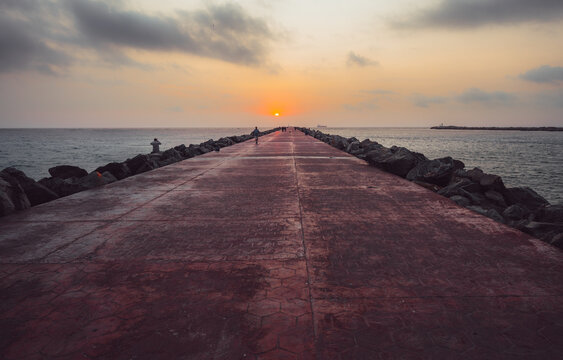 Malecon with sunrise in the background, from both sides you can see the ocean