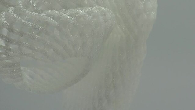 white foam basket. white foam net for fruit wrapping. roll up mesh foam container for apples, pears, vegetables, eggs and more on a white background