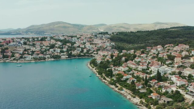 Aerial view of a city on an island in Croatia. Beautiful red roofs of houses on the Adriatic sea promenade with parked boats in a landscape city.