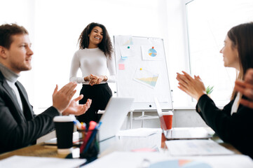 Successful business woman present own project at briefing meeting. Beautiful african american lady boss talk with colleagues, discuss plans and strategies of company, smile