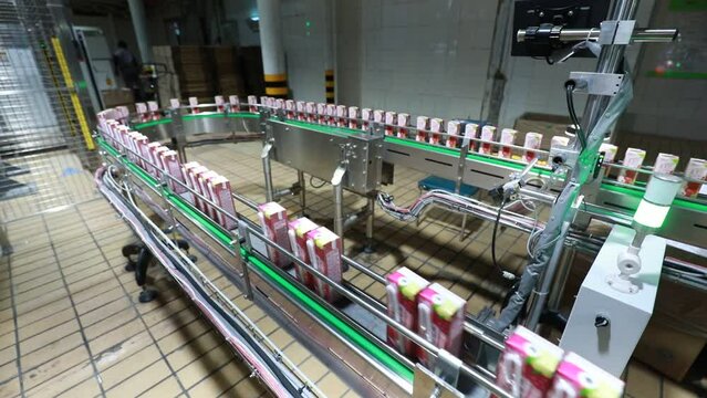 Workers work hard on the dairy production line in Mengniu Dairy Co., Ltd, North China