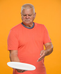 displeased senior man with a clean plate. an elderly man with disdain shows an empty plate on a...