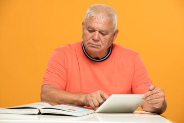 senior man learning to work with a tablet