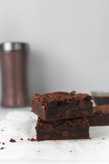 Stack of fudgy brownies on a sheet of parchment paper, milk chocolate brownies