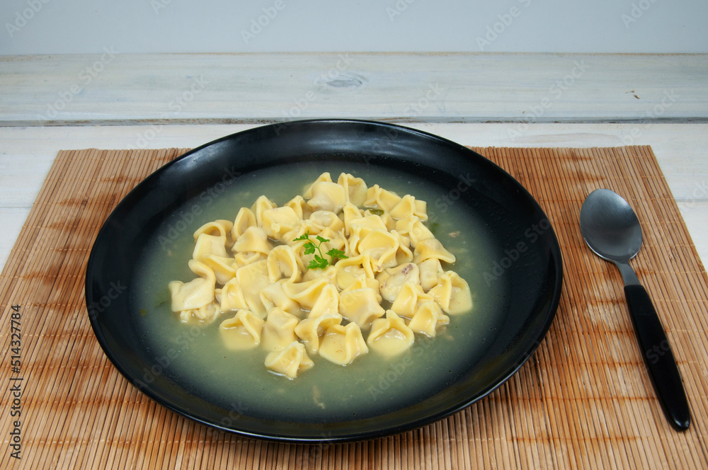 Wall mural close up view of delicious agnoline in black bowl