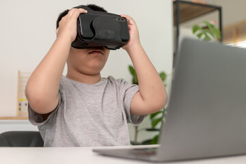 Asian Little boy with VR glasses studying sciences at home,curious student wears a virtual reality headset to study science home online study futuristic lifestyle learning