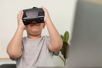 Asian Little boy with VR glasses studying sciences at home,curious student wears a virtual reality headset to study science home online study futuristic lifestyle learning