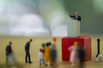 Miniature people : politician or party candidate in excited speech persuades to vote for him. - obrazy, fototapety, plakaty