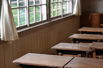 窓から光が射しこむ日本の古い小学校の教室