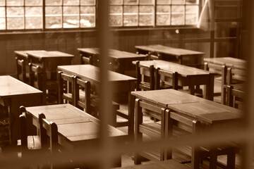 窓から光が射しこむ日本の古い小学校の教室