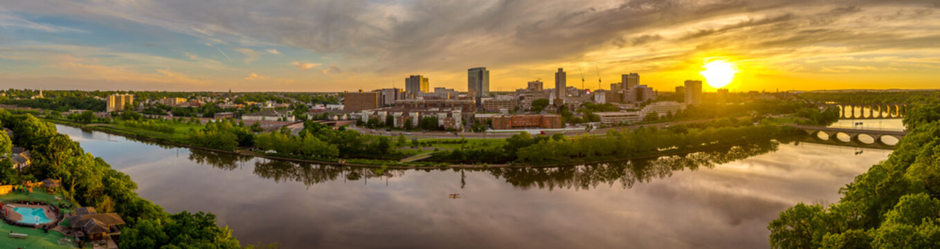 Aerial view of downtown New Brunswick and Rutgers University as the sun sets behind the high rise buildings and reflect on the Raritan river