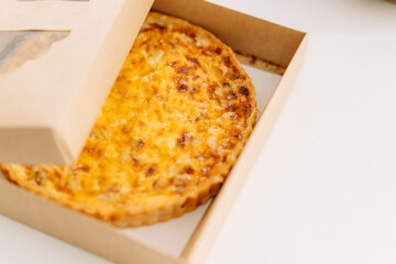 Pie with red fish in a box on a white table.