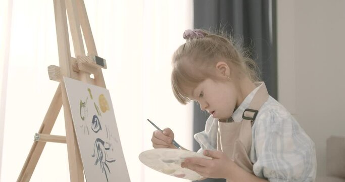 Little girl with down syndrome drawing at home